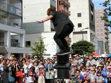 円柱の板に乗る大道芸