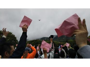 上空のドローンやヘリに手を振ってます